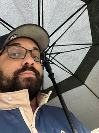 Max Woghiren, under an umbrella in the rain